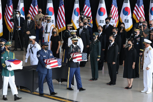 문재인 대통령과 김정숙 여사가 참석한 가운데 22일(현지시각) 미국 히캄 공군기지 19번 격납고에서 열린 한미 유해 상호 인수식에서 의장병이 유해를 항공기로 운구하고 있다.    연합뉴스